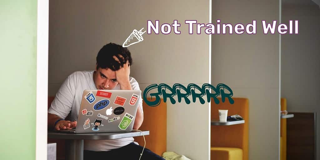 Man sitting in public workspace on a laptop looking aggravated with hand to head with text overlayed "not trained well" and "grrrrr."