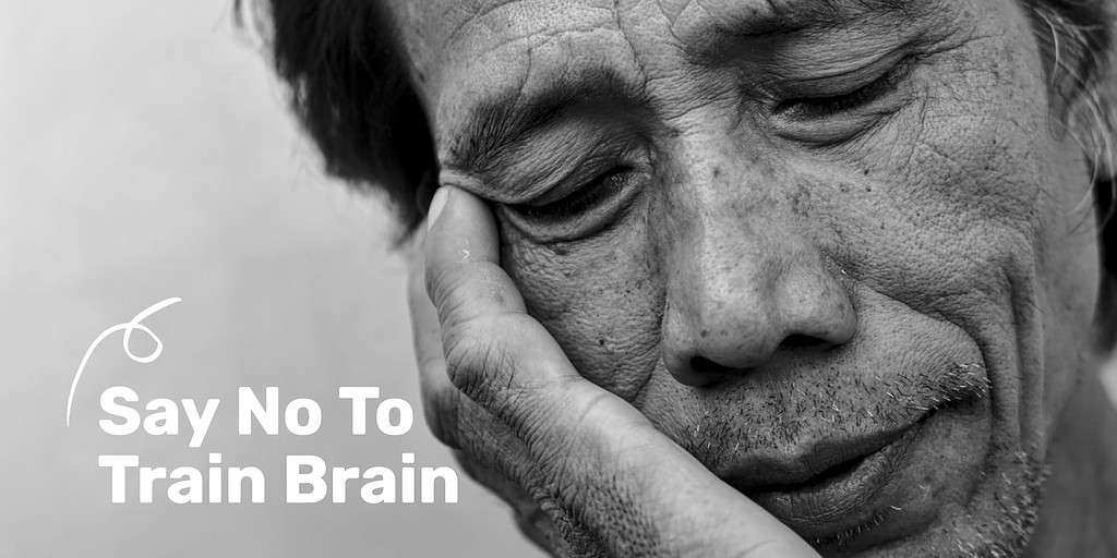 A man leaning on his hand looking tired with the text overlay "Say No To Train Brain."