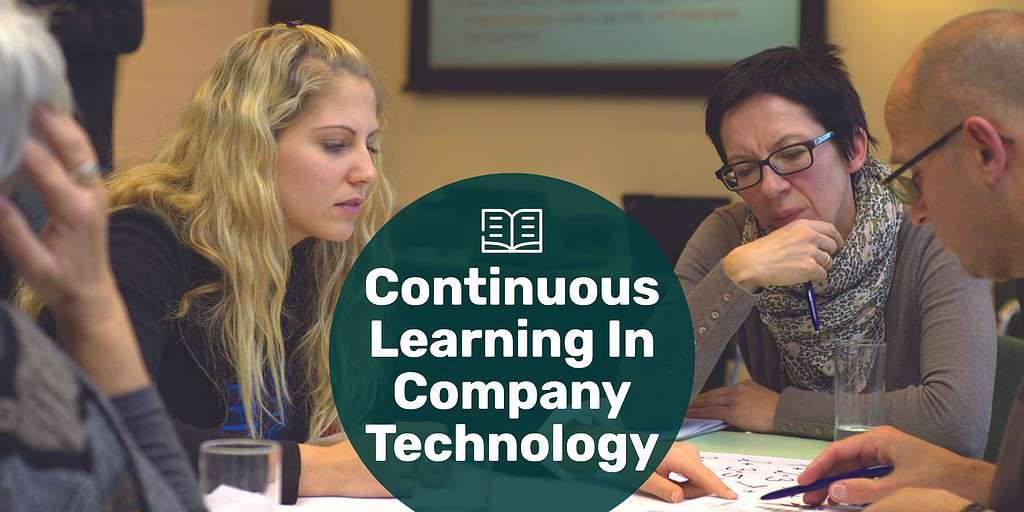 Adults around a table working and learning with text overlay "continuous learning in company technology."